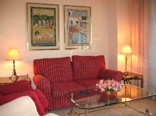 Das Wohnzimmer ist anpsprechend mit einer roten Couch und zwei Sesseln eingerichtet