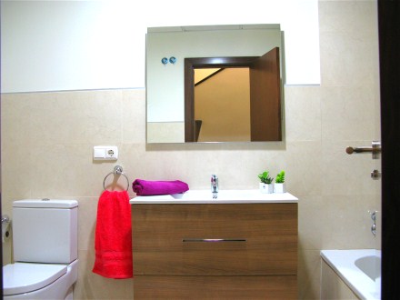 Das Bad hat eine Wanne und einen Waschtisch mit großem Spiegel