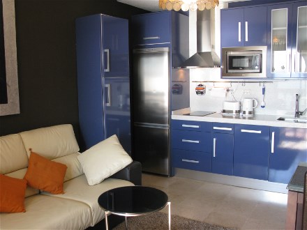 Die blaue, moderne Einbauküche mit großem Kühlschrank ist gut ausgestattet